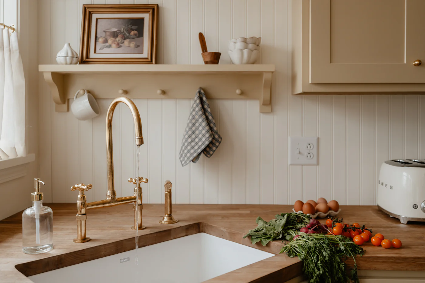 Cottage kitchen with a ceramic sink, open shelves and fresh local produce